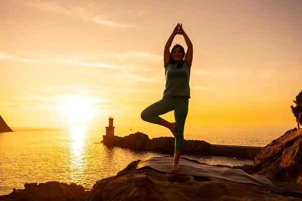 Woman doing meditation yoga exercises on Lido Tourist beach