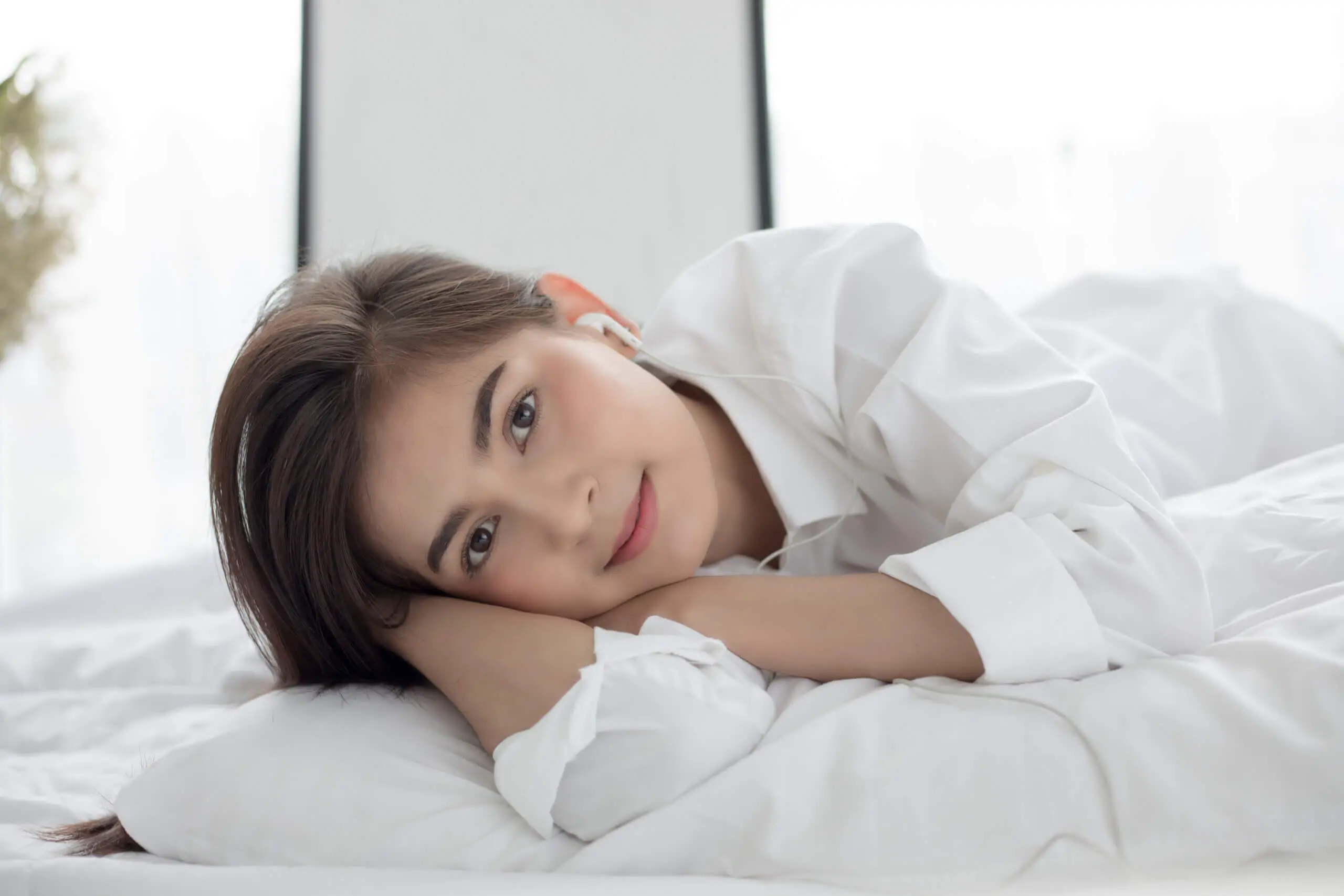 Asian woman Smile feel carefree and she lying on the bed in the morning 