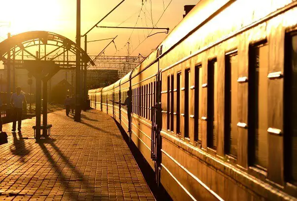 Train leaving railway station sunset
