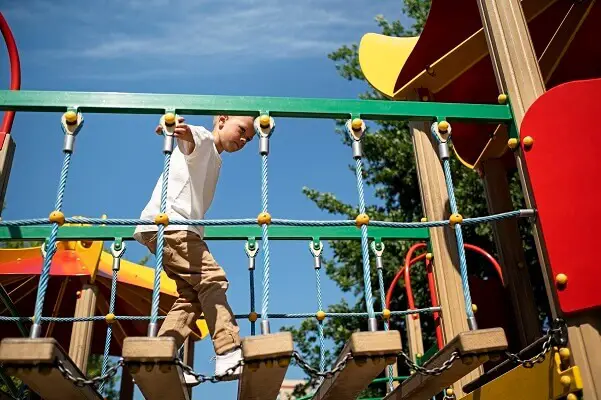 Young boy having fun outdoors playground