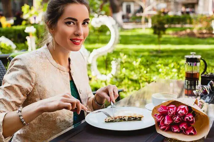 Young stylish woman sitting cafe eating tasty pie